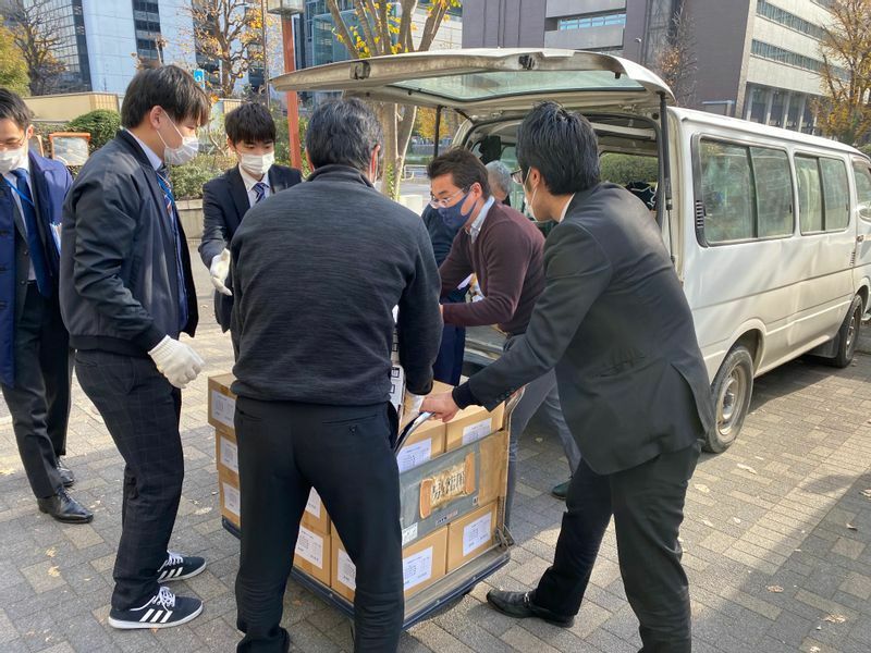 2020年12月18日、福島県から到着したNPO法人FUKUSHIMAいのちの水の車両に備蓄食料を積み込む農林水産省の方々（筆者撮影）