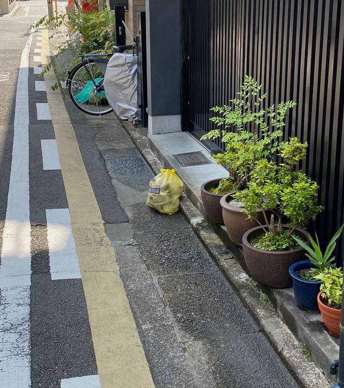ごみ収集の日、京都市の指定袋に小さくまとめて家屋前に出されたごみ（筆者撮影）