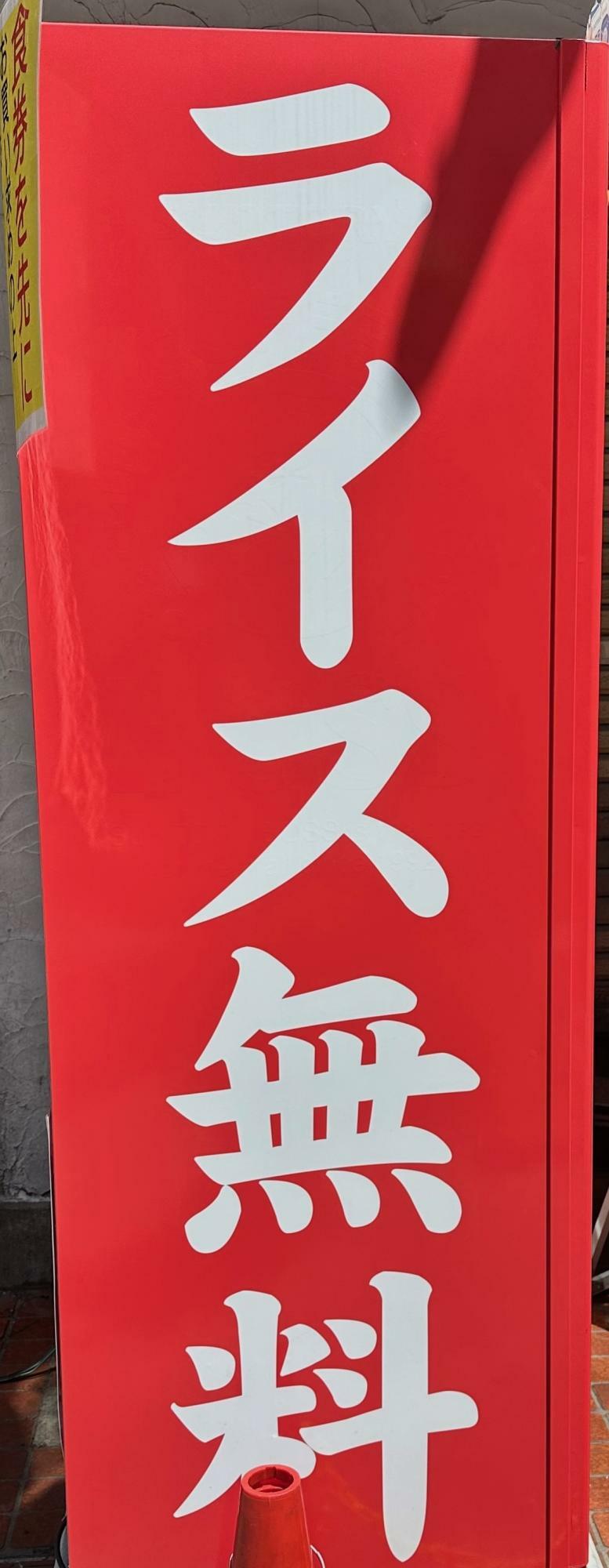 ラーメン店の前に掲げられた「ライス無料」の文字（筆者撮影）