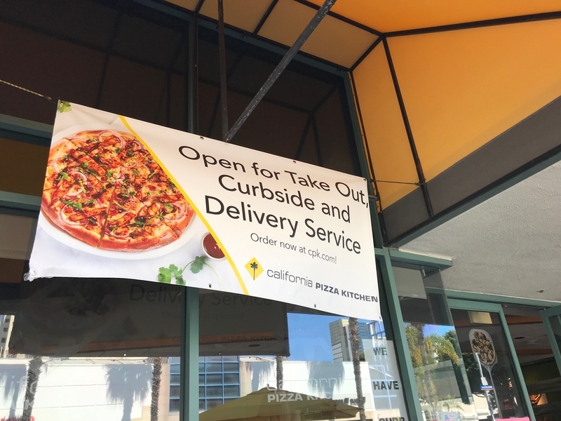 テイクアウトができ、デリバリーも行なっているピザレストランチェーンのカリフォルニア・ピザ・キッチン。入り口には、発熱している人は入店お断りの貼り紙もされている。筆者撮影。