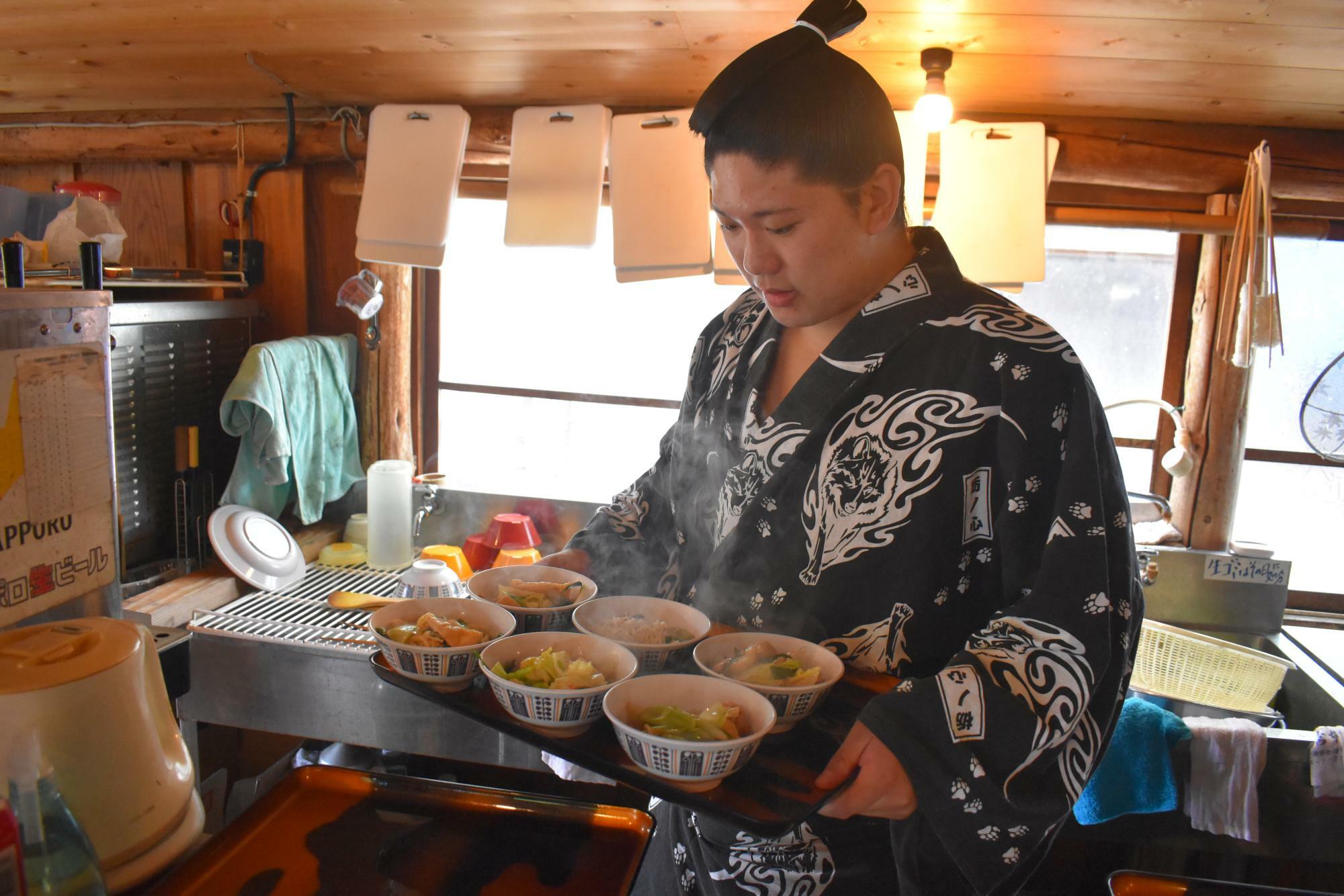この日の鍋は、世話人の荒ノ浪さんが作ったソップ（しょうゆ）鍋。写真は給仕に勤しむ序二段の鷹司