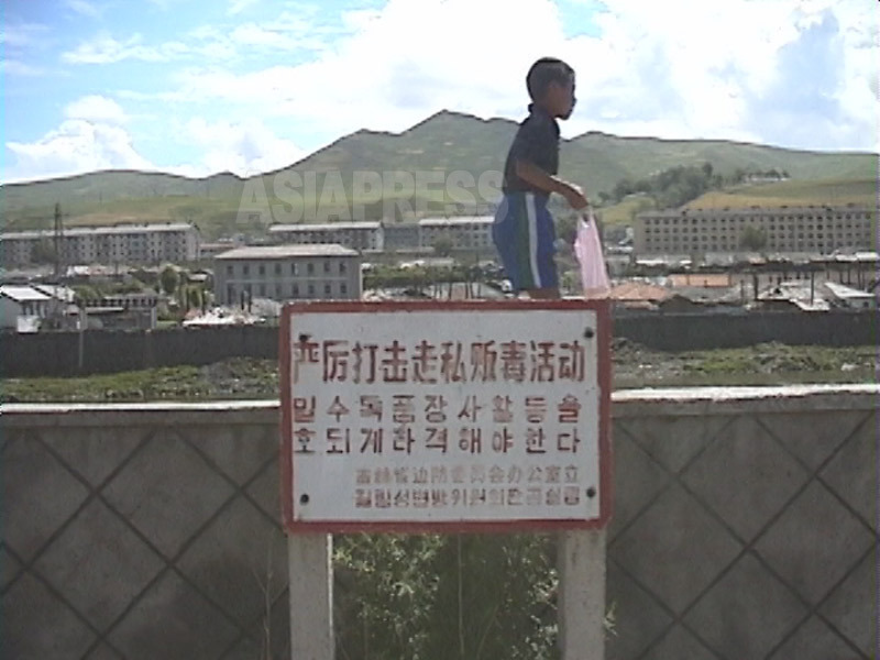 中国側に掲げられた「麻薬密輸活動を許すな」の立て札。背後は北朝鮮。1999年8月