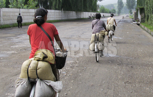 (参考写真)取り締まりを避けるために裏道を自転車で疾走する食糧運びの女性たち。2008年8月平壌市郊外の農村部で、撮影チャン・ジョンギル（アジアプレス）