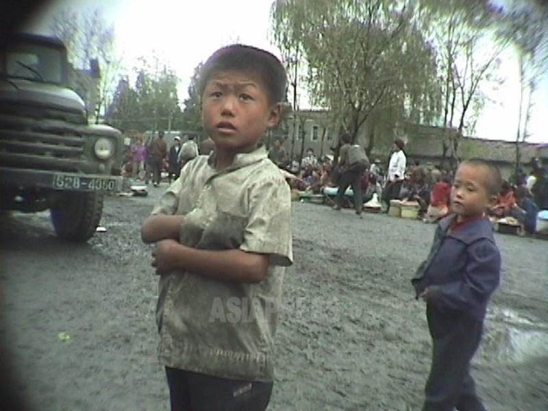 街を彷徨う幼い兄妹。「母が死んだ」という。大社会混乱期の1998年10月に江原道元山市にて撮影アン・チョル（アジアプレス）