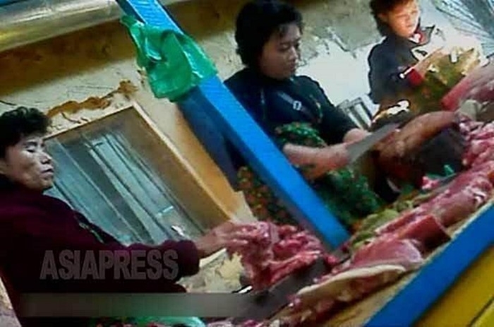 (参考写真)豚の生肉を切り分ける商売人の女性たち。2012年11月北朝鮮北部の国境都市の市場で。撮影アジアプレス