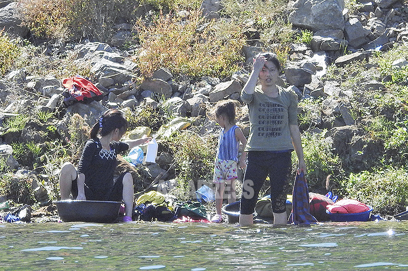 鴨緑江で洗濯する女性たち。飲料水としても用いられ、夏場は水浴びする人も多い。平安北道の朔州（サクジュ）郡　
