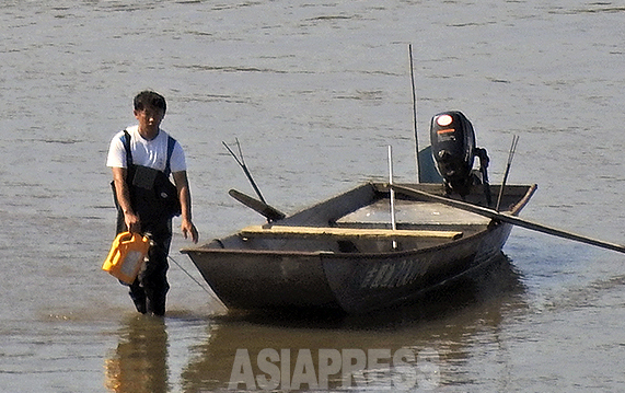 豆満江の中に入って何かの作業中の中国人男性。吉林省の琿春市防川