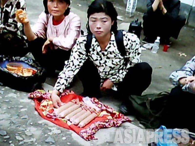 平壌市中心部のアパート街で中国製のソーセージを売る女性。2011年7月モラン区域にて取材パートナーのク・グァンホが撮影した。