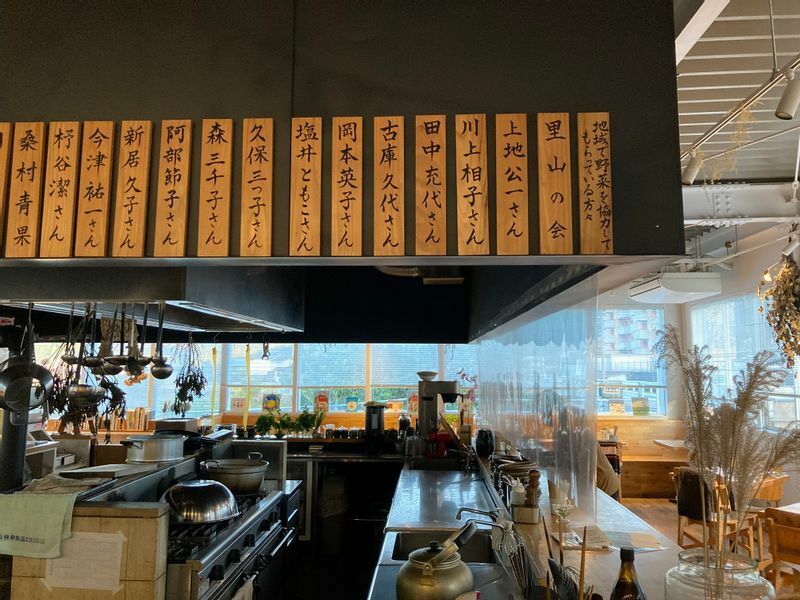「かま屋」店内には、野菜を提供する生産者の名札が掛けられている。（筆者撮影）