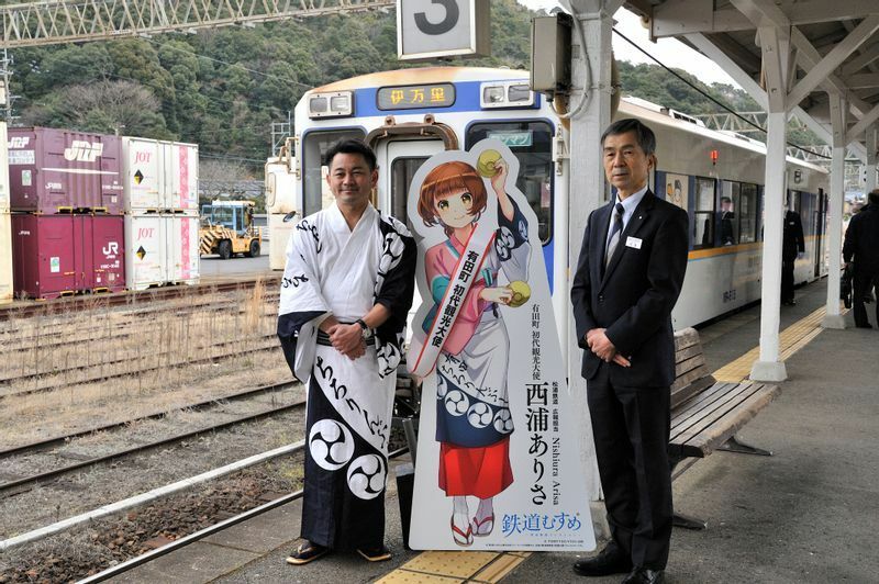 有田駅での就任式で撮影に応じる松尾佳昭町長（左）と松浦鉄道の今里晴樹社長（右）