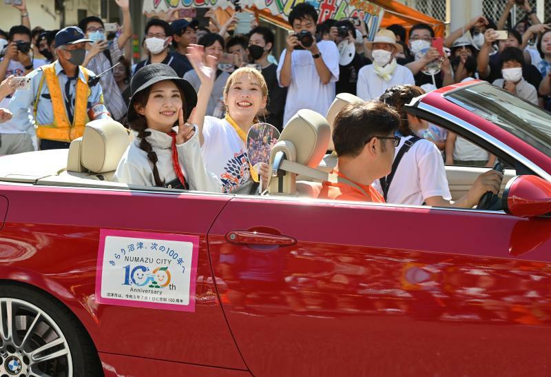 市制100周年記念パレードでのAqoursの小宮有紗さん（左）、高槻かなこさん（左奥）。助手席で奥側を向いているのが斉藤朱夏さん