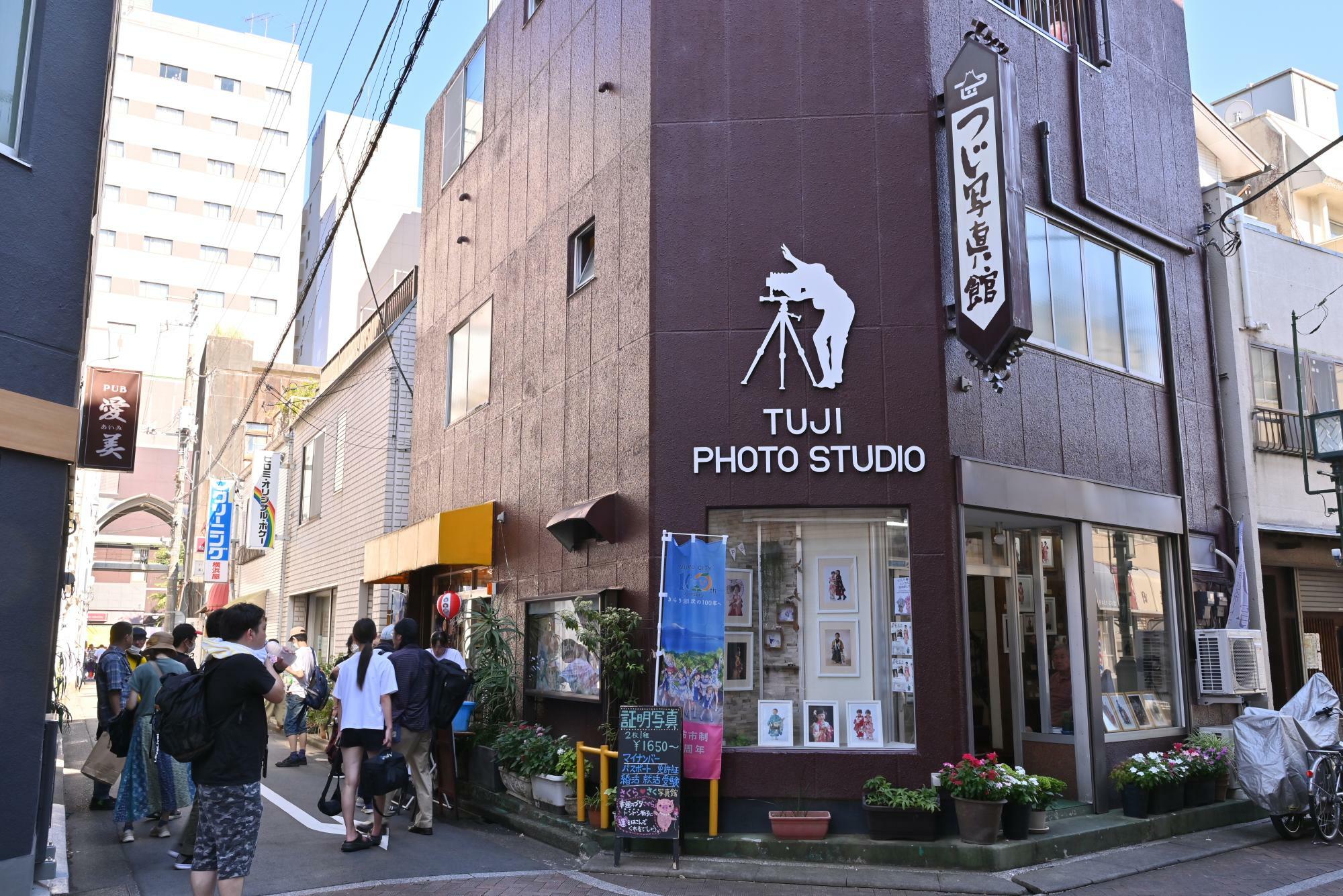 沼津市のあげつち商店街にあるつじ写真館。『サンシャイン!!』のスピンオフアニメ『幻日のヨハネ』でも舞台モデルとして登場した。今でも「ラブライブ！」ファンが世界中から集まる場所だ