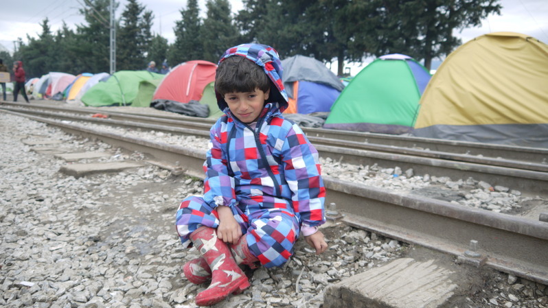 線路に独りぼっちで座る難民の少年（3月、イドメニで筆者撮影）