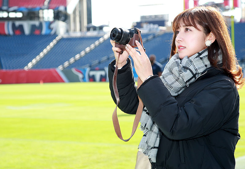 NFLのスタジアムでカメラを構える『のぎ天写真部』初代部長の斎藤ちはる（三尾圭撮影）