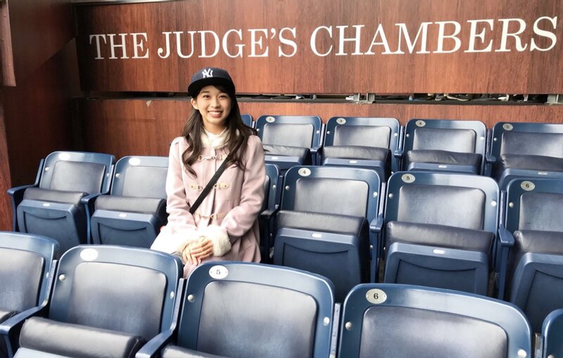 ヤンキー・スタジアムの「ジャッジズ・チェンバース」席に座って記念写真を撮る牧野真莉愛（公式ブログより）