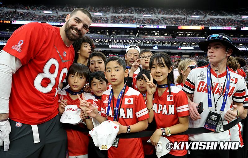 ボルティモア・レイブンズのマーク・アンドリュース（左）と一緒に写真に収まる日本チームの子どもたち（写真：三尾圭）