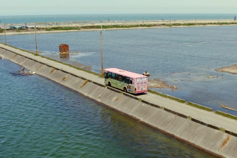 台湾の西南部、嘉義県、東石村の水辺を走るピンク色のバス