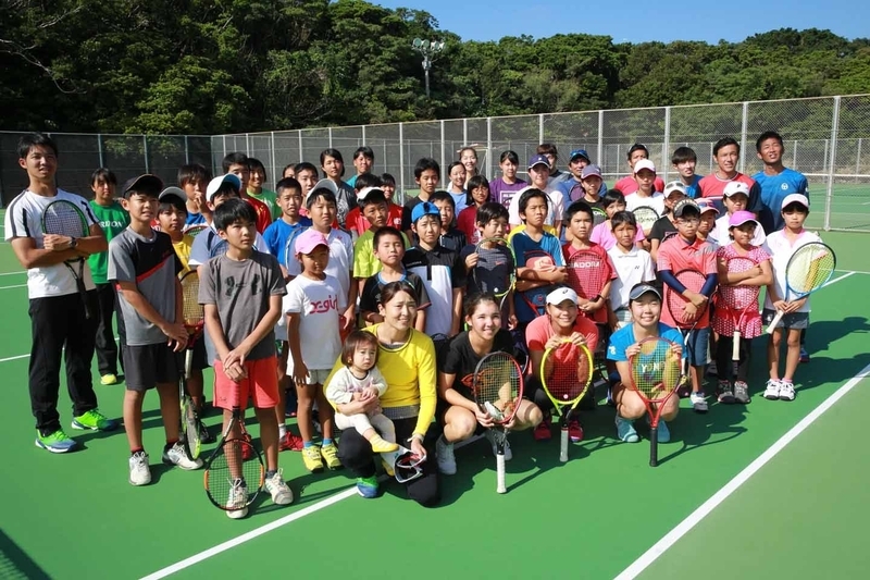 沖縄で開催されたテニスクリニックで、子供たちと記念撮影をする尾崎と村松