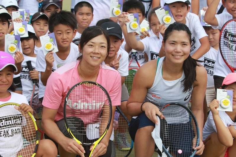 沖縄で開催されたテニスクリニックで、子供たちと記念撮影をする尾崎（写真右）と加治