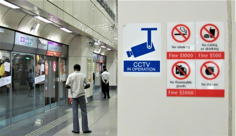 車内飲食に罰金（約4万円）を科すとするシンガポールの駅構内標識（右上、筆者撮影）