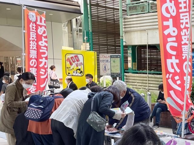 通勤客が行き交う場所で行われた街頭署名活動=4月30日、大阪市都島区で。「カジノの是非は府民が決める 住民投票をもとめる会」の城東区連絡会提供