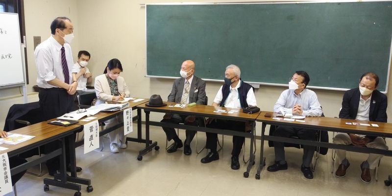 全国一長い商店街で知られる「天神橋筋商店街」の店主らと意見交換する菅直人・元首相(左)。大阪が誘致しようとしているカジノについても話題になった=2022年5月29日、大阪市北区で、筆者撮影