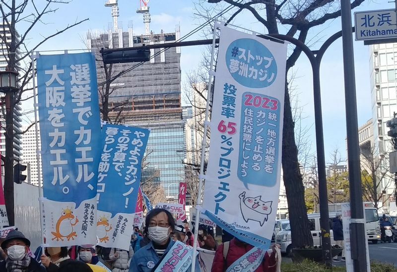 市民らによるカジノ反対のパレードでは、選挙で棄権せずに投票を呼び掛ける幟旗が登場した＝2023年２月11日、大阪市中央区で、筆者撮影