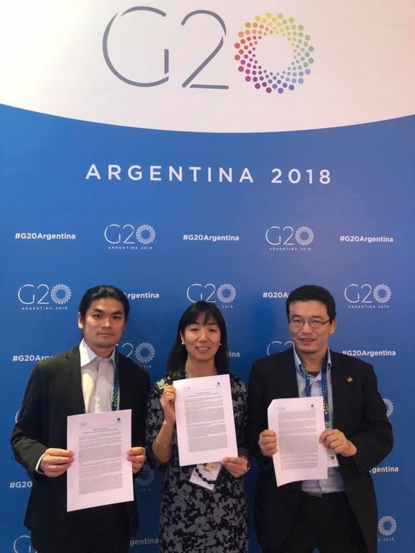 G20ブエノスアイレス・サミット首脳宣言を持つ2019 G20サミット市民社会プラットフォーム事務局メンバー。宣言への意見を募り来年のサミットに生かしたいと述べる（撮影：アルゼンチンNGO関係者）