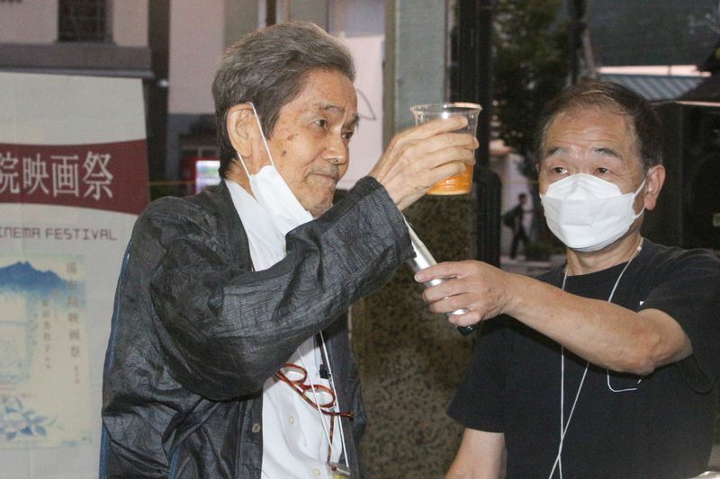 酒を愛した伊藤雄さんを偲び、献杯三唱の音頭をとる中谷顧問（左）。右は三宮実行委員長。（筆者撮影）