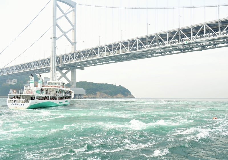 大鳴門橋の近くを通る観潮船。潮流が激しくなる時間帯は多くの観光客が乗船する