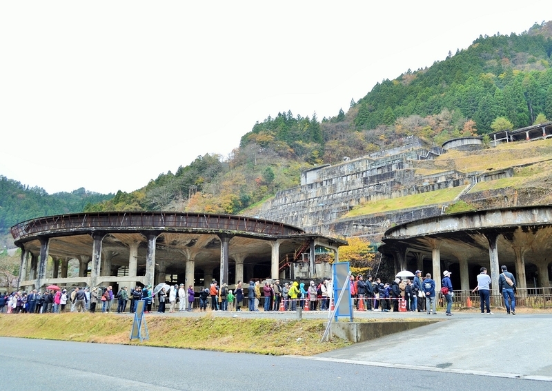 神子畑選鉱場跡の最上部へ向かうバスを待つ人々