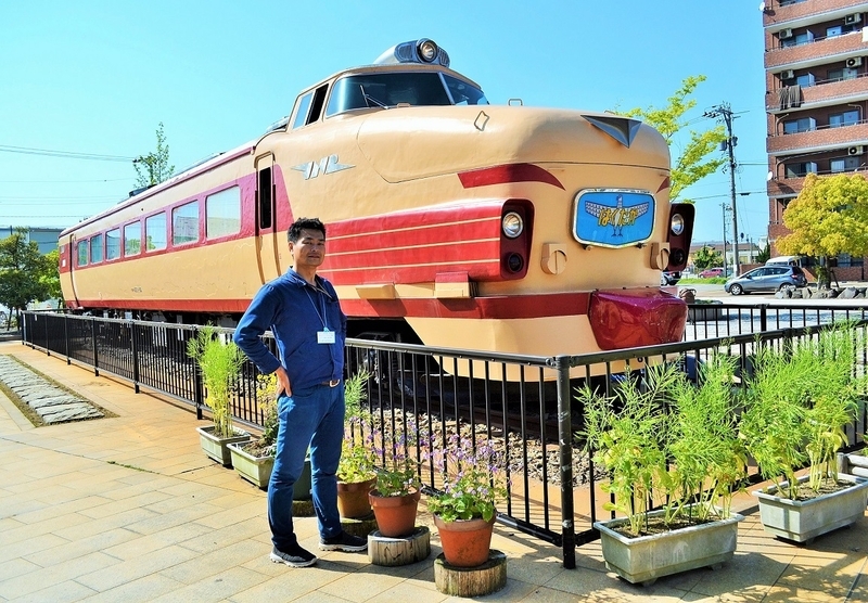 小松市の「土居原ボンネット広場」に展示されているボンネット型特急電車「クハ489-501」と岩谷さん(2018年4月撮影)