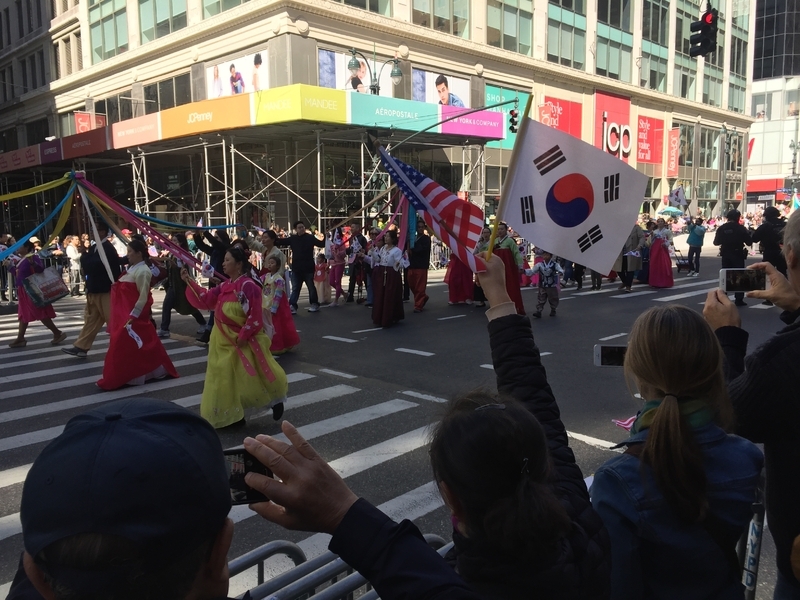 米韓の旗を振るパレードの見物客