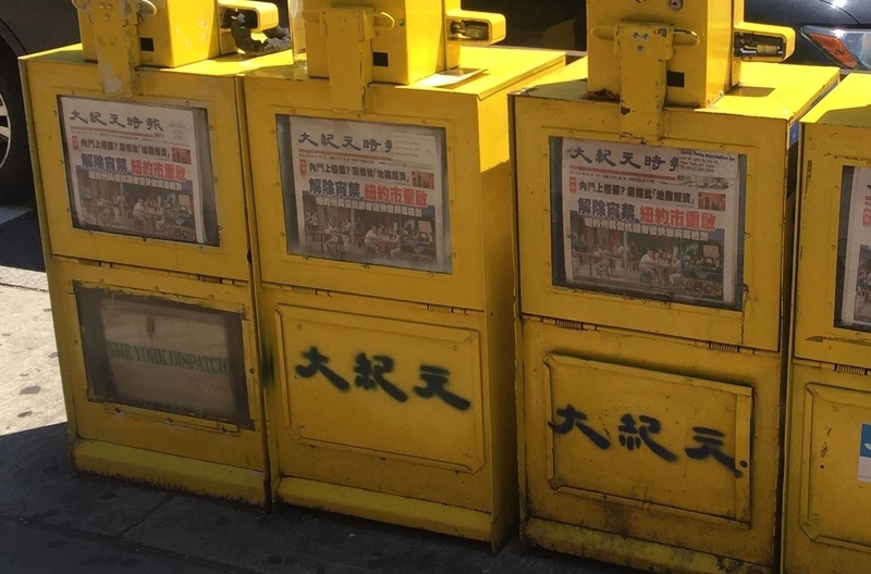 市の経済再開を伝える中国語のローカル紙＝8日、マンハッタン