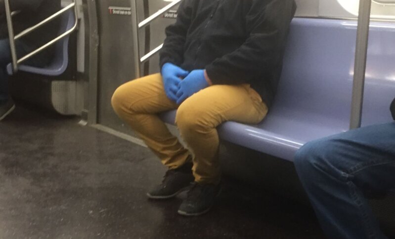手袋をはめた地下鉄の乗客＝2020年4月、ニューヨーク市