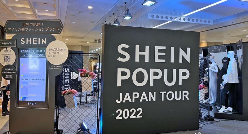 会場のボードには「アメリカ発ファッションブランド」と表示 (筆者撮影)