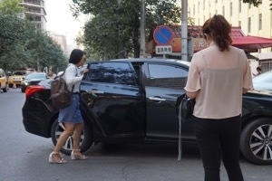 若い女性が配車アプリで呼んだ車に乗るのは日常的な光景（北京にて）