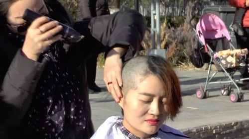 髪を剃って抗議する李文足（2018年12月17日北京にて撮影）