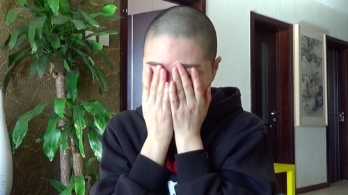 夫の判決を聞いた後、取材の途中で李文足は何度も顔を覆った（2019年1月28日北京にて撮影）