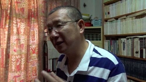 本に囲まれる部屋で取材に応じる馬少方さん(去年8月深セン)