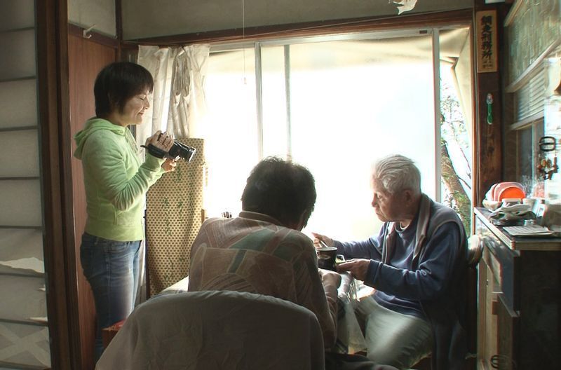 食卓を囲む両親にカメラを向ける信友直子さん(左)=(c)2018「ぼけますから、よろしくお願いします。」製作・配給委員会