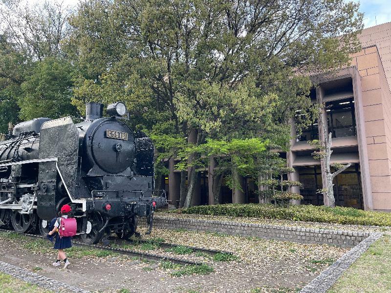 広島市こども図書館（右側）の前にはC59形蒸気機関車があり、子どもたちに人気＝2022年4月、広島市中区（筆者撮影）