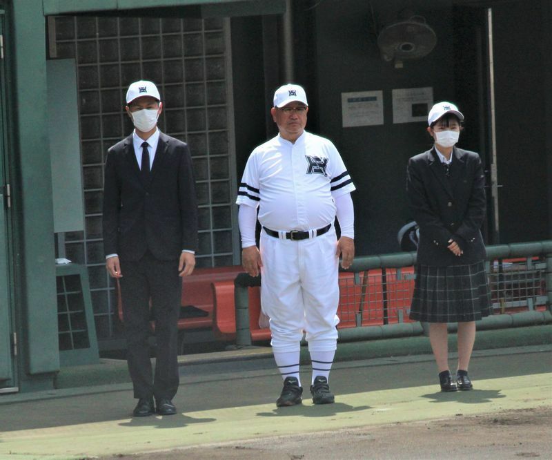 彦根総合を率いる宮崎監督（中央）。ユニフォームはクラシカルな純白仕様で、本人は「原点回帰」だとか。胸のマークのHとSの形は、母校・比叡山の現役時代の帽子のマークを模している（筆者撮影）