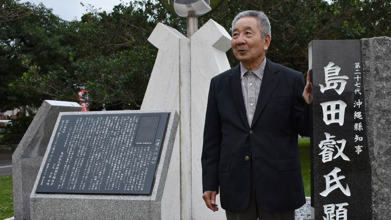 島田叡氏顕彰碑の前で話す嘉数昇明氏（写真：ストライク・ゾーン）