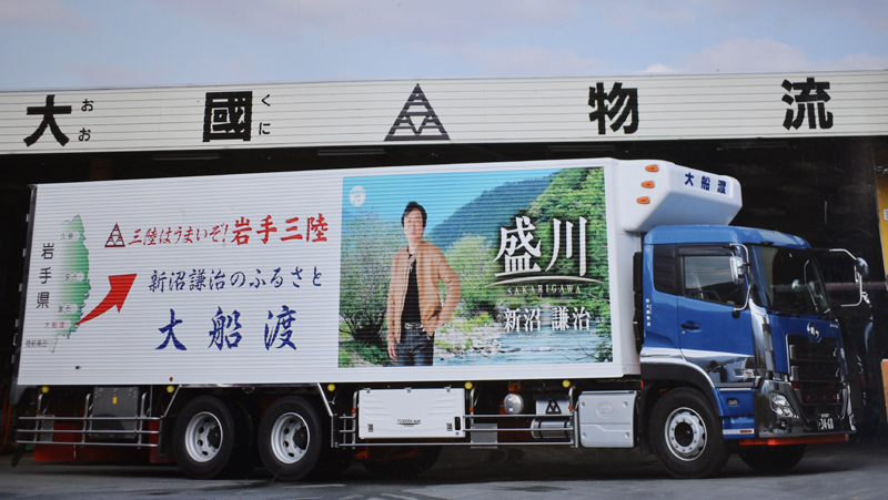 新沼謙治さんの写真と大船渡の紹介がラッピングされたトラック（写真：大國物流）