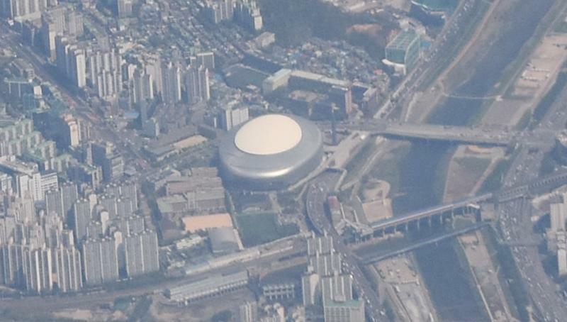 飛行機機内からコチョクドーム上空。写真右側にアニャン（安養）川が流れる。クイル駅のホームは東大島駅（東京都）、武庫川駅（兵庫県）のように川の上にある。写真手前（写真：ストライク・ゾーン）