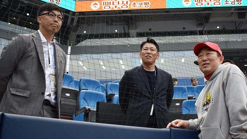 24日の韓国シリーズ第3戦を視察に訪れた侍ジャパン井端弘和監督（写真中）、吉見一起コーチ（左）と談笑する中村武志コーチ（写真：ストライク・ゾーン）