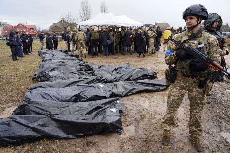 ブチャで発見された多数の民間人の遺体のそばで警備にあたるウクライナ兵士(2022.4.8)