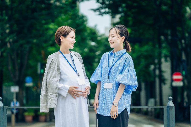 妊娠中の女性と話すビジネスウーマン(イメージ)。