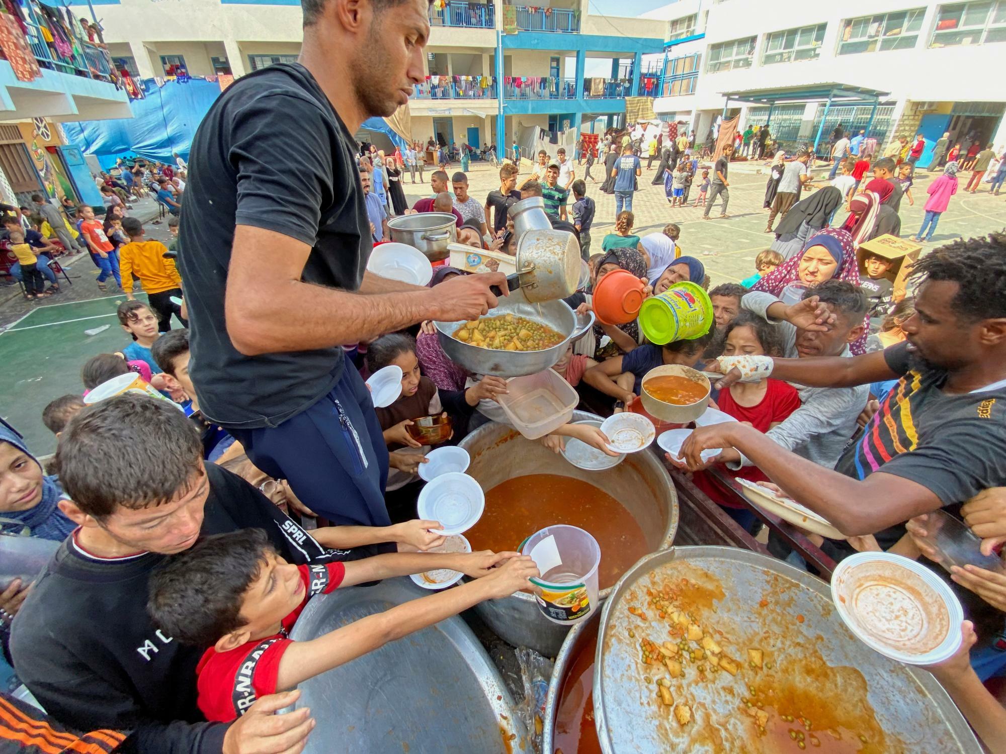 避難所になっているガザの学校で食糧の配給を行う援助関係者（2023.10.23）。